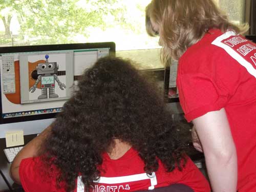 Megan helps a camper with a robot band picture
