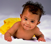 a girl toddler crawls across a bed.