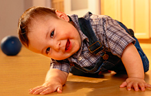 boy toddler played with ball because there is a ball in the background.