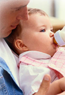 man feeding child with bottle