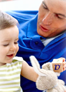 man teaching and playing with child about literacy because an alphabet block is present.
