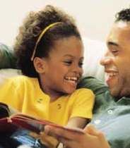 man reading a book to a girl