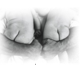 black and white image of a man snuggling two nude babies.