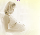 pregnant woman snuggling belly while bathed in light